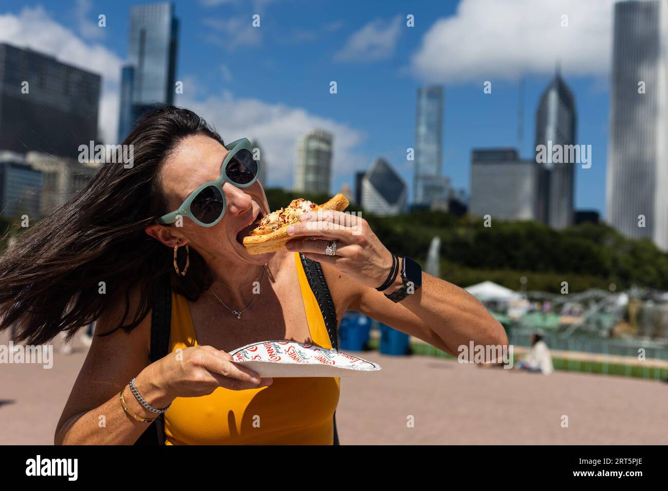 230910 -- CHICAGO, 10 settembre 2023 -- Una donna mangia un pezzo di pizza profonda in stile Chicago durante il Taste of Chicago nel centro di Chicago, negli Stati Uniti, il 9 settembre 2023. Circa 35 ristoranti e 15 food truck hanno partecipato all'evento 2023. Foto di /Xinhua U.S.-CHICAGO-TASTE OF CHICAGO VincentxD.xJohnson PUBLICATIONxNOTxINxCHN Foto Stock