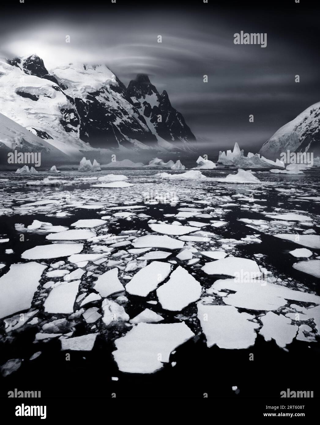Banchi di ghiaccio vicino al Circolo polare antartico con nubi di lenticularis sulla vetta della montagna. Di solito quest'area è congelata. Foto Stock