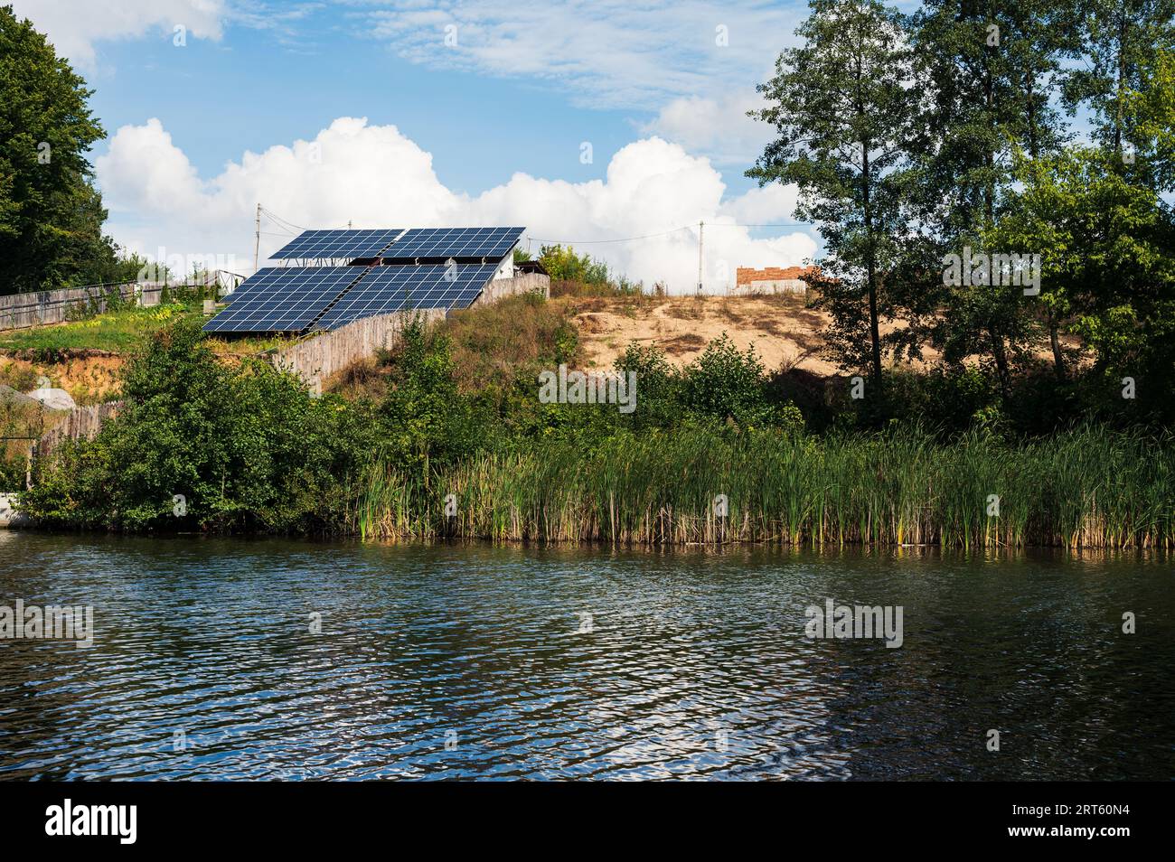 Centrale solare con pannelli solari sulla riva del fiume. Energia solare pulita, ecologia, tema ecologico Foto Stock