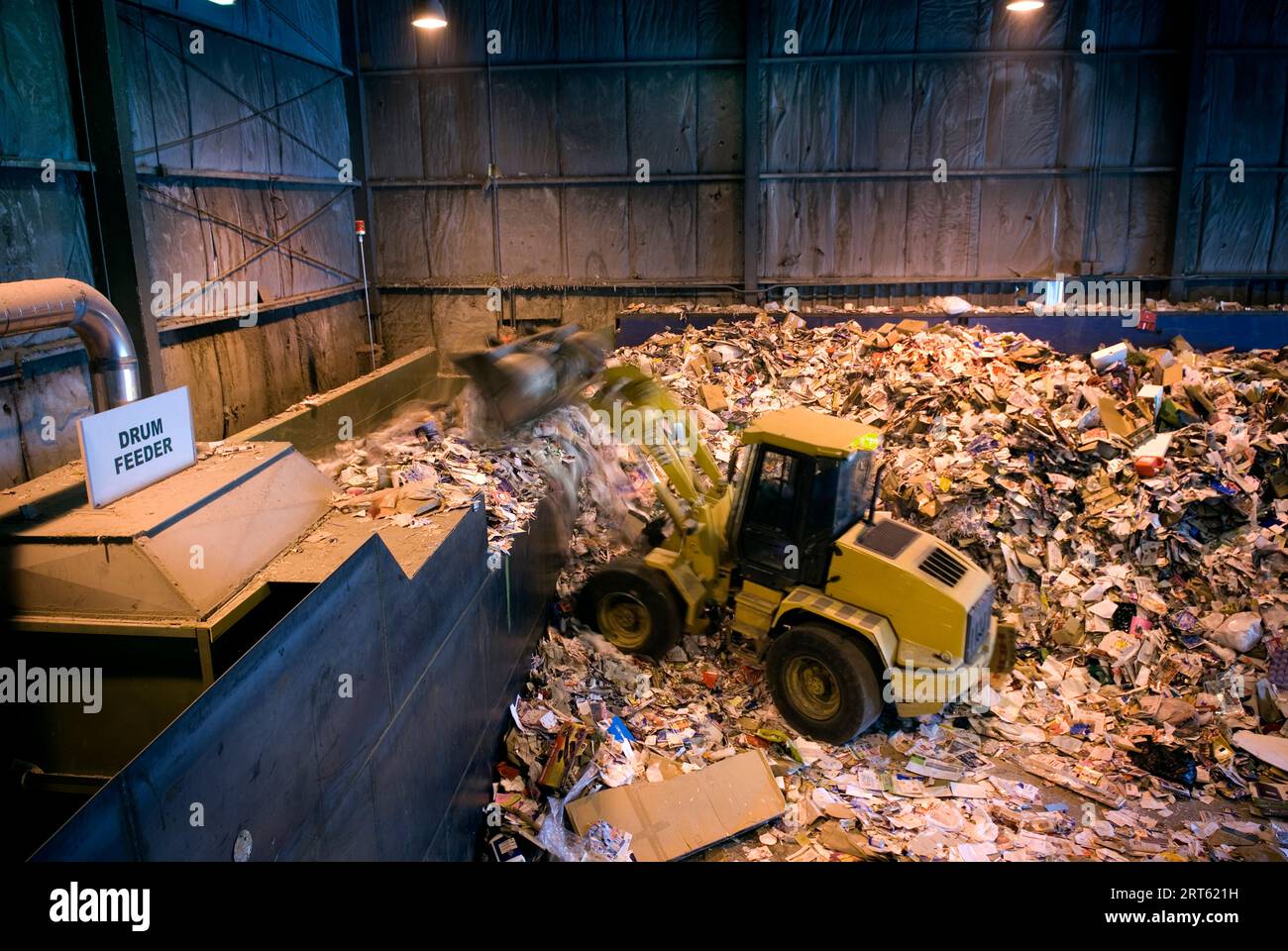 Scaricare carta e cartone per lo smistamento di autocarri in un impianto di riciclaggio. Foto Stock