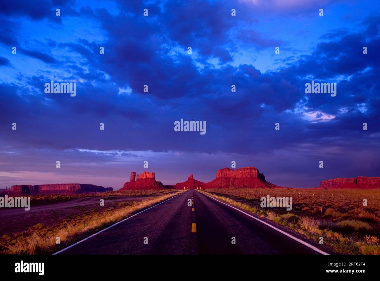 La terra che circonda la Monument Valley, situata sul confine tra Arizona e Utah, è un vasto e vuoto deserto pieno di incredibili scenari a perdita d'occhio. Foto Stock