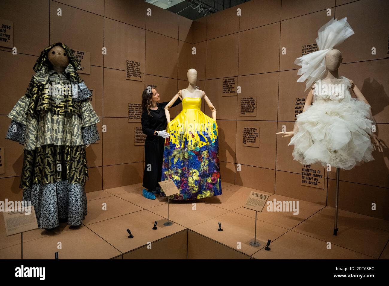 Londra, Regno Unito. 11 settembre 2023. A staff member with (C) Embroidered Dress, Autunno/Inverno 2008, by Erdem in anteprima di "REBEL: 30 Years of London Fashion", una nuova mostra di moda contemporanea al Design Museum che esamina il ruolo di protagonista della capitale nella moda globale. In collaborazione con il British Fashion Council, la mostra celebra il 30° anniversario del programma NEWGEN del BFC con quasi 100 look realizzati o concepiti a Londra in mostra dal 16 settembre all'11 febbraio 2024. Crediti: Stephen Chung / Alamy Live News Foto Stock