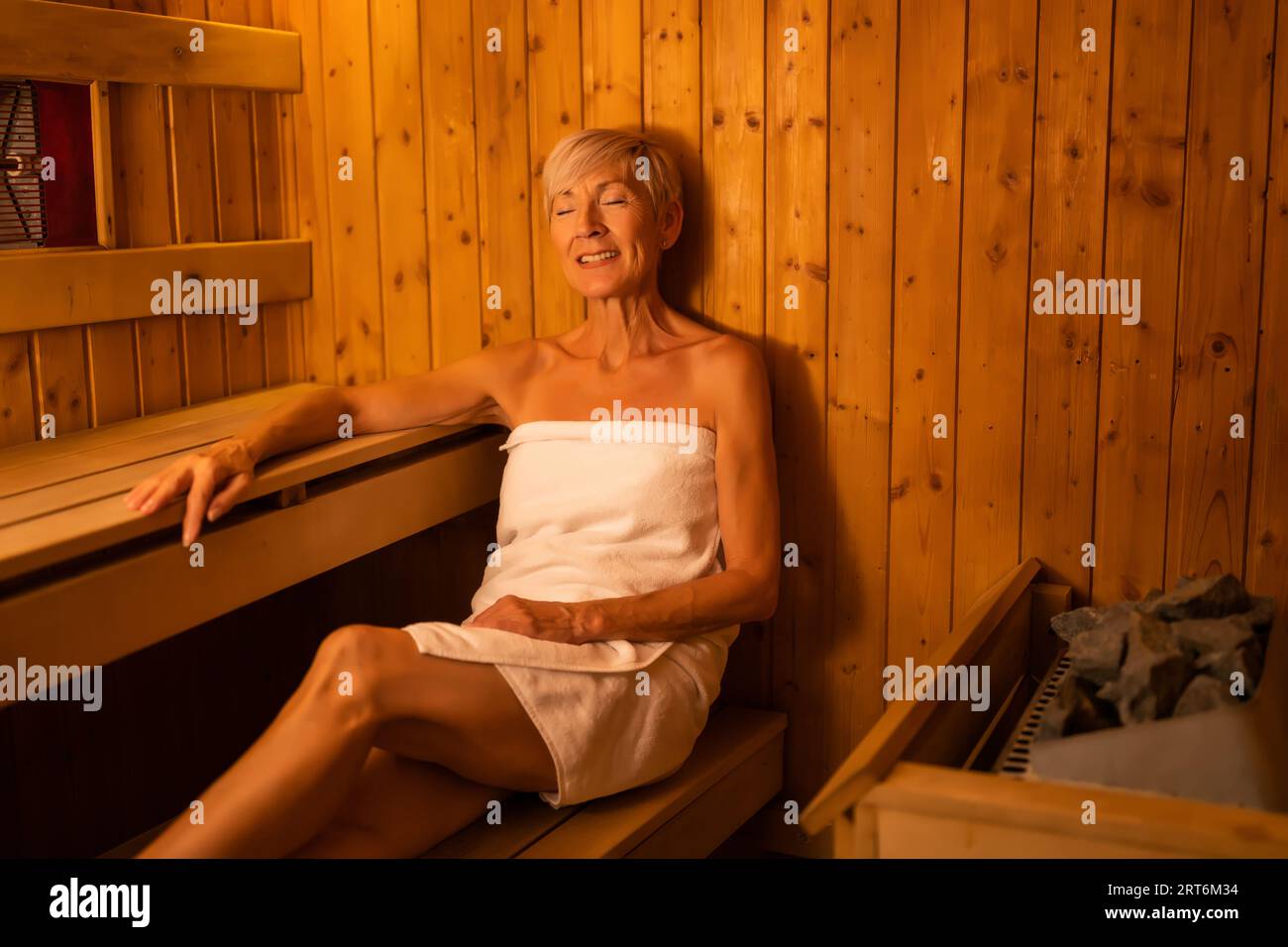 Una donna matura si sta rilassando nella sauna. Stile di vita sano per le persone anziane. Concetto Spa. Foto Stock