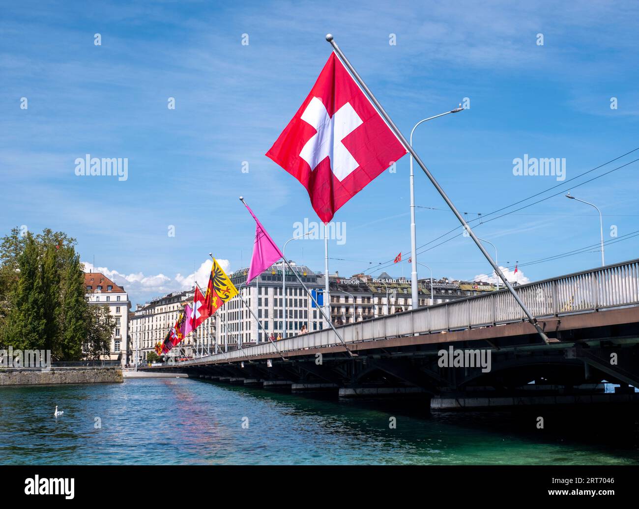 La bandiera svizzera è appesa al Pont du Mont-Blanc, nel centro di Ginevra, in Svizzera Foto Stock