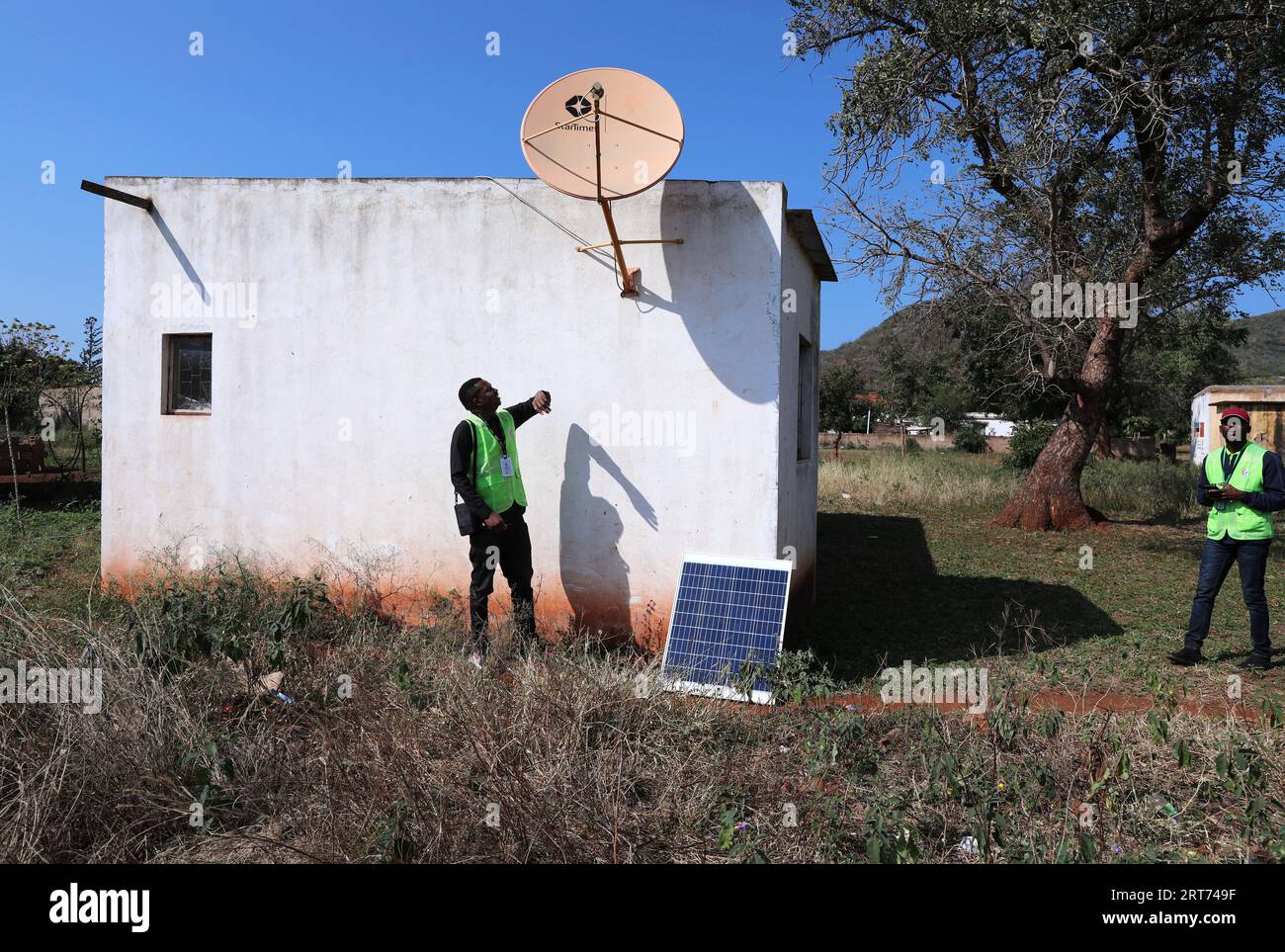 (230911) -- MAPUTO, 11 settembre 2023 (Xinhua) -- Nunes Guardagea (L) e il suo collega controllano l'antenna ricevente della televisione satellitare con aiuti cinesi nel villaggio di Goba, provincia di Maputo, Mozambico, 26 luglio 2023. Il governo del Mozambico ha annunciato nel maggio 2020 il completamento di un progetto per portare il segnale televisivo digitale satellitare a 1.000 villaggi del paese, che ha beneficiato oltre 20.000 famiglie. Il progetto, che copre tutte le dieci province e la capitale del Mozambico, è stato cofinanziato dalla Cina e implementato dalla società cinese di elettronica e media StarTimes. Ha addestrato la forza lavoro Foto Stock