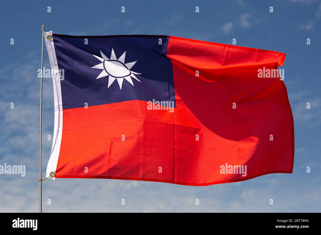 Sullo sfondo del cielo blu, la bandiera di Taiwan fluttua sul flagpole Foto Stock