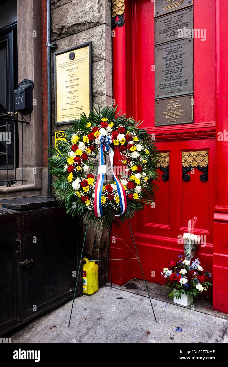 Ricordo del 9/11 con fiori davanti alla lista dei vigili del fuoco persi nella caserma 9/11 Squad 18 sulla 10th St, Greenwich Village, New York City, NY Foto Stock