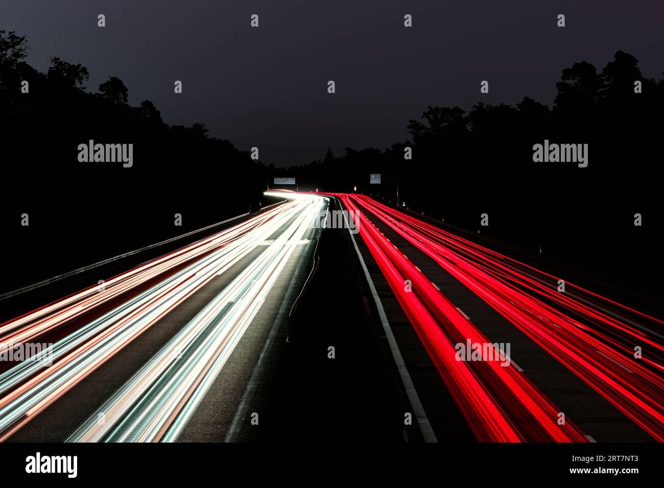Piste luminose per auto. Luci sull'autostrada. Tracce di auto. Luce astratta, Lichtschweife. Autostrada al tramonto e molto traffico. Autostrada di notte. Foto Stock
