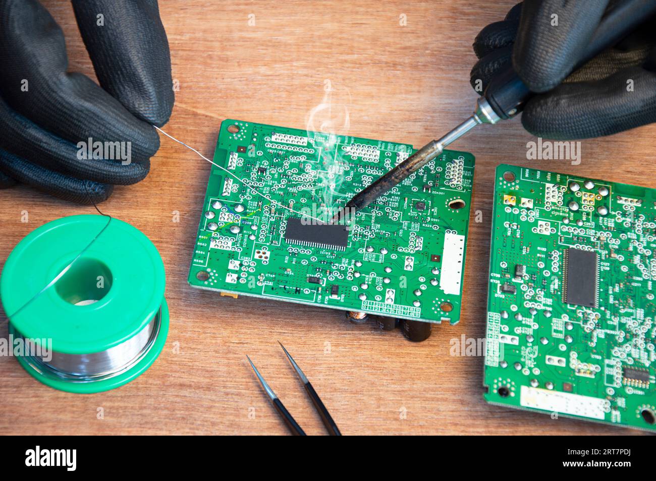 Primo piano di saldatura maschio dei componenti di riparazione della scheda madre Foto Stock