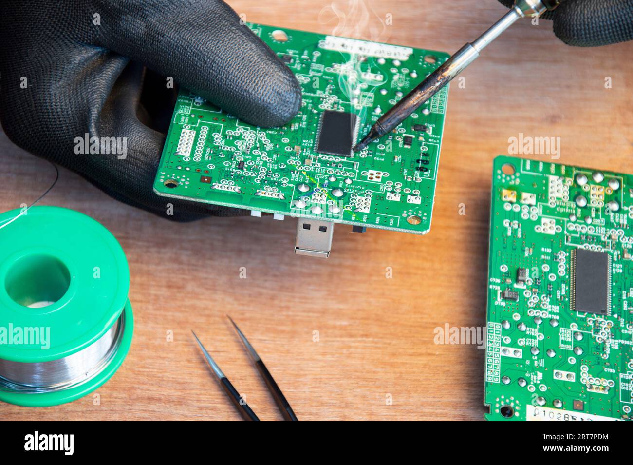 Primo piano di saldatura maschio dei componenti di riparazione della scheda madre Foto Stock