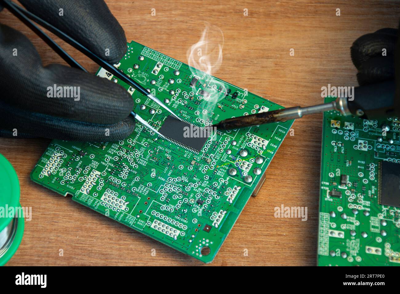 Primo piano di saldatura maschio dei componenti di riparazione della scheda madre Foto Stock