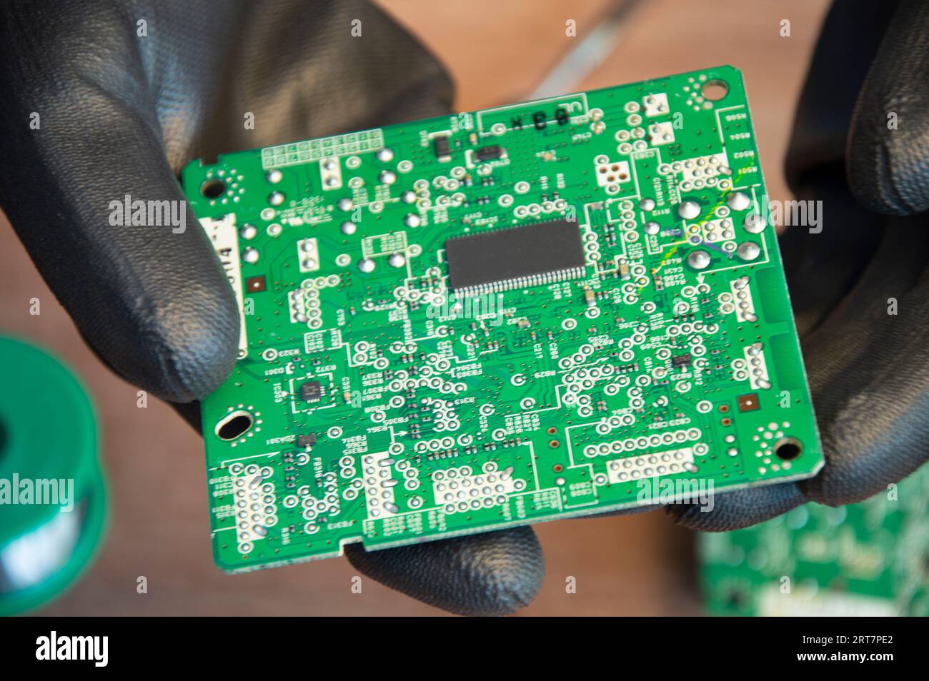 Primo piano di saldatura maschio dei componenti di riparazione della scheda madre Foto Stock