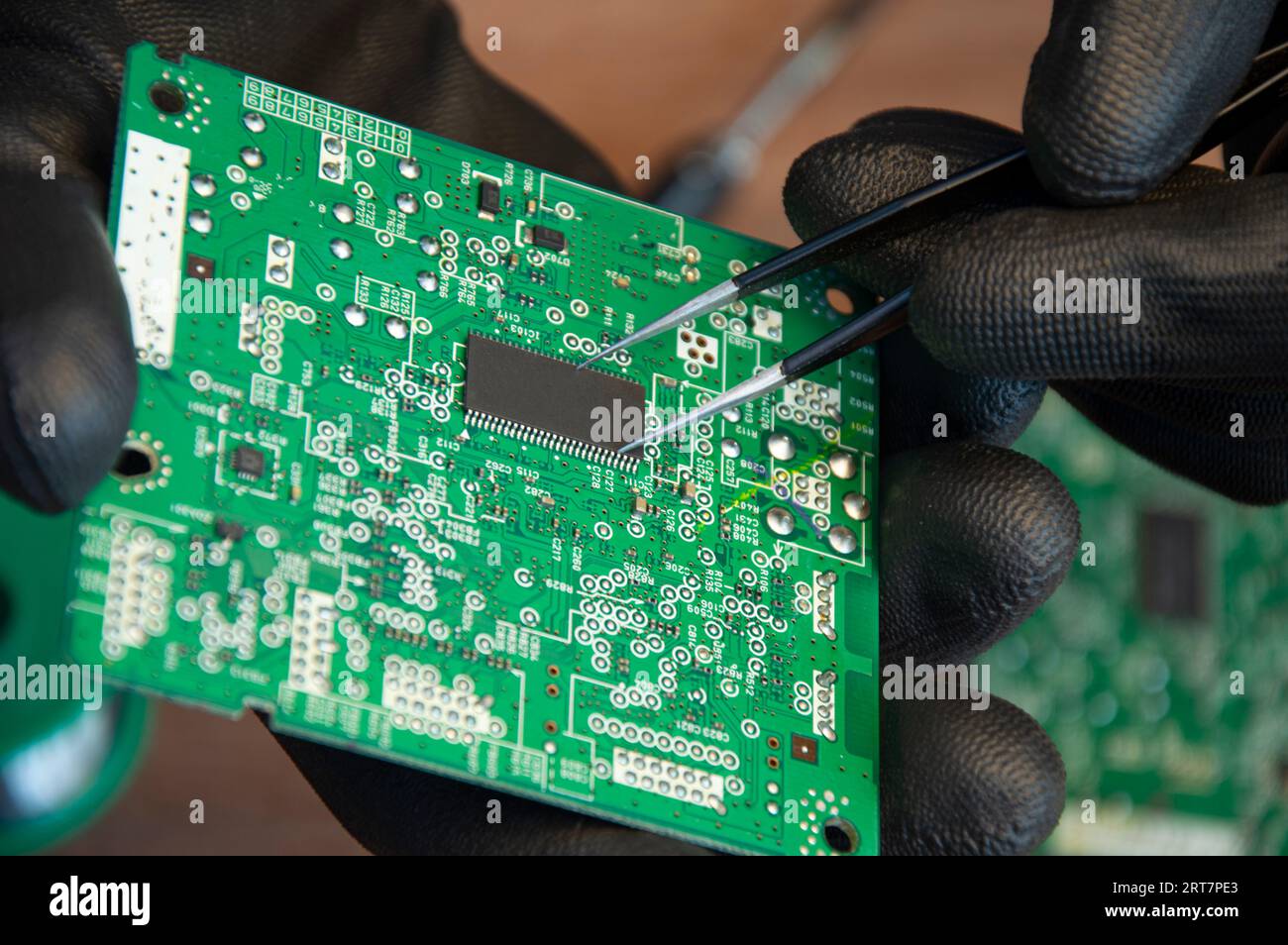 Primo piano di saldatura maschio dei componenti di riparazione della scheda madre Foto Stock