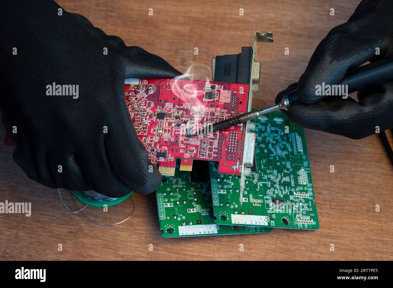 Primo piano di saldatura maschio dei componenti di riparazione della scheda madre Foto Stock