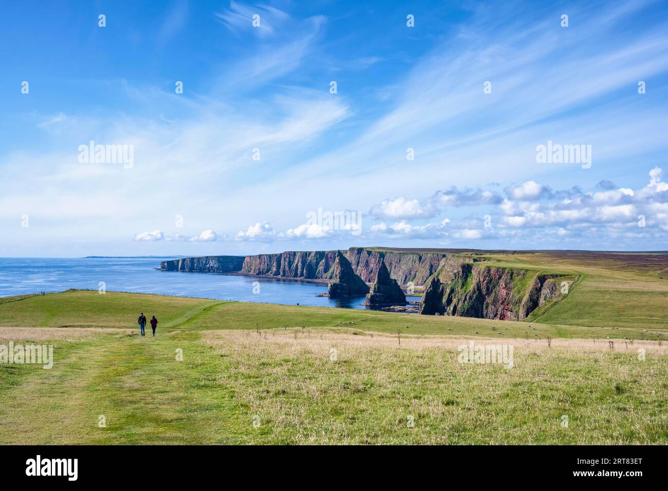 Due turisti che camminano fino ai Duncansby Stacks, sulla punta nord-orientale della Scozia, County Caithness, Scozia, Regno Unito Foto Stock