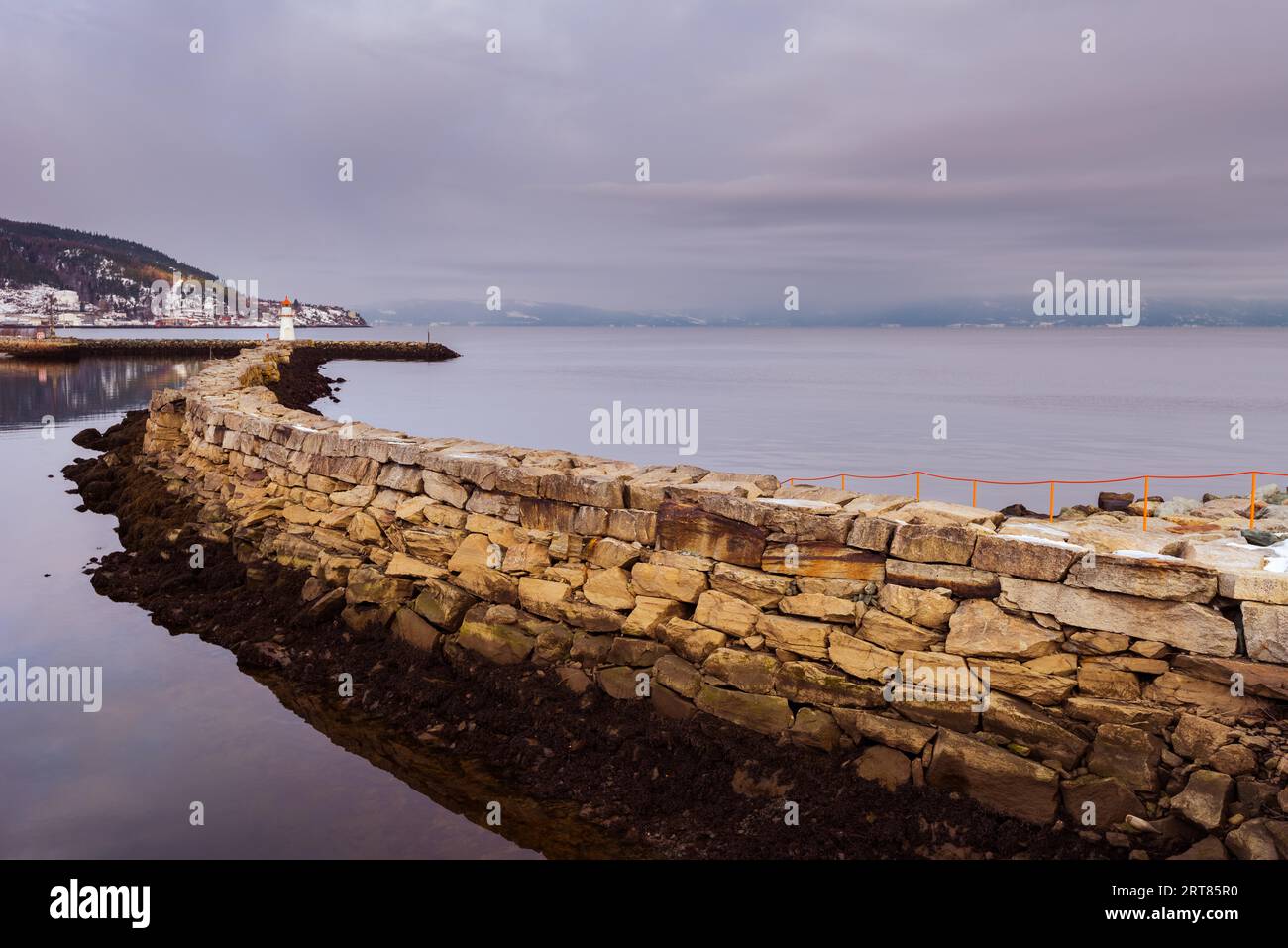 Muro di Quay con faro del porto di Trondheim su una parete giorno invernale Foto Stock