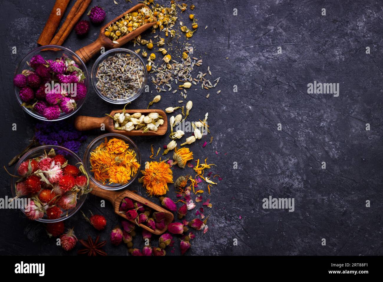 Assortimento di fiori secchi su tè nero ardesia pietra con spazio di copia Foto Stock