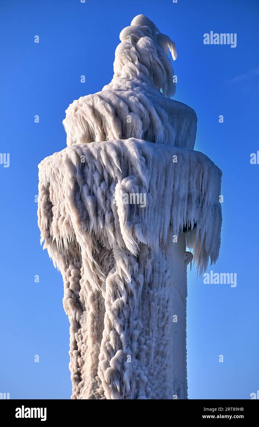 Faro ghiacciato e molo nelle tempeste giornate invernali Foto Stock