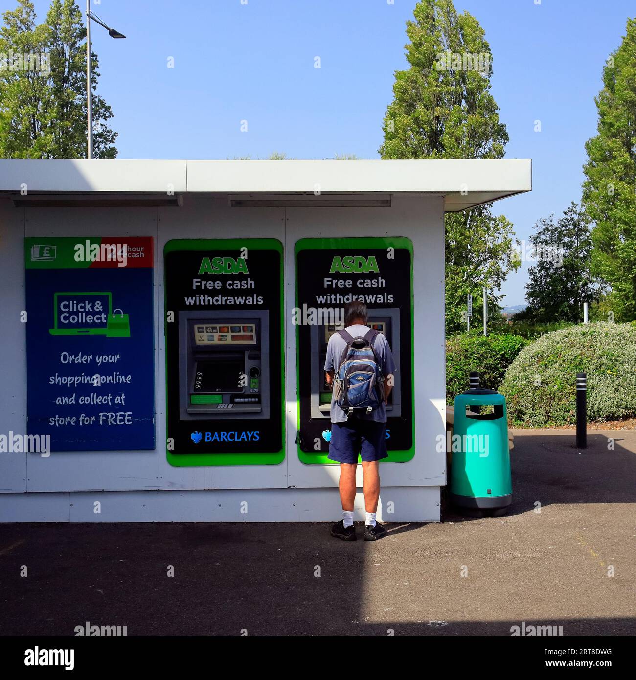 Un uomo al bancomat che prende soldi dal bancomat Foto Stock
