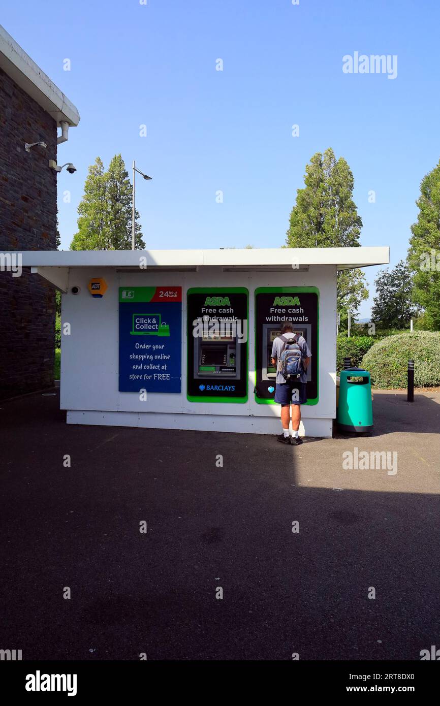 Un uomo al bancomat che prende soldi dal bancomat Foto Stock