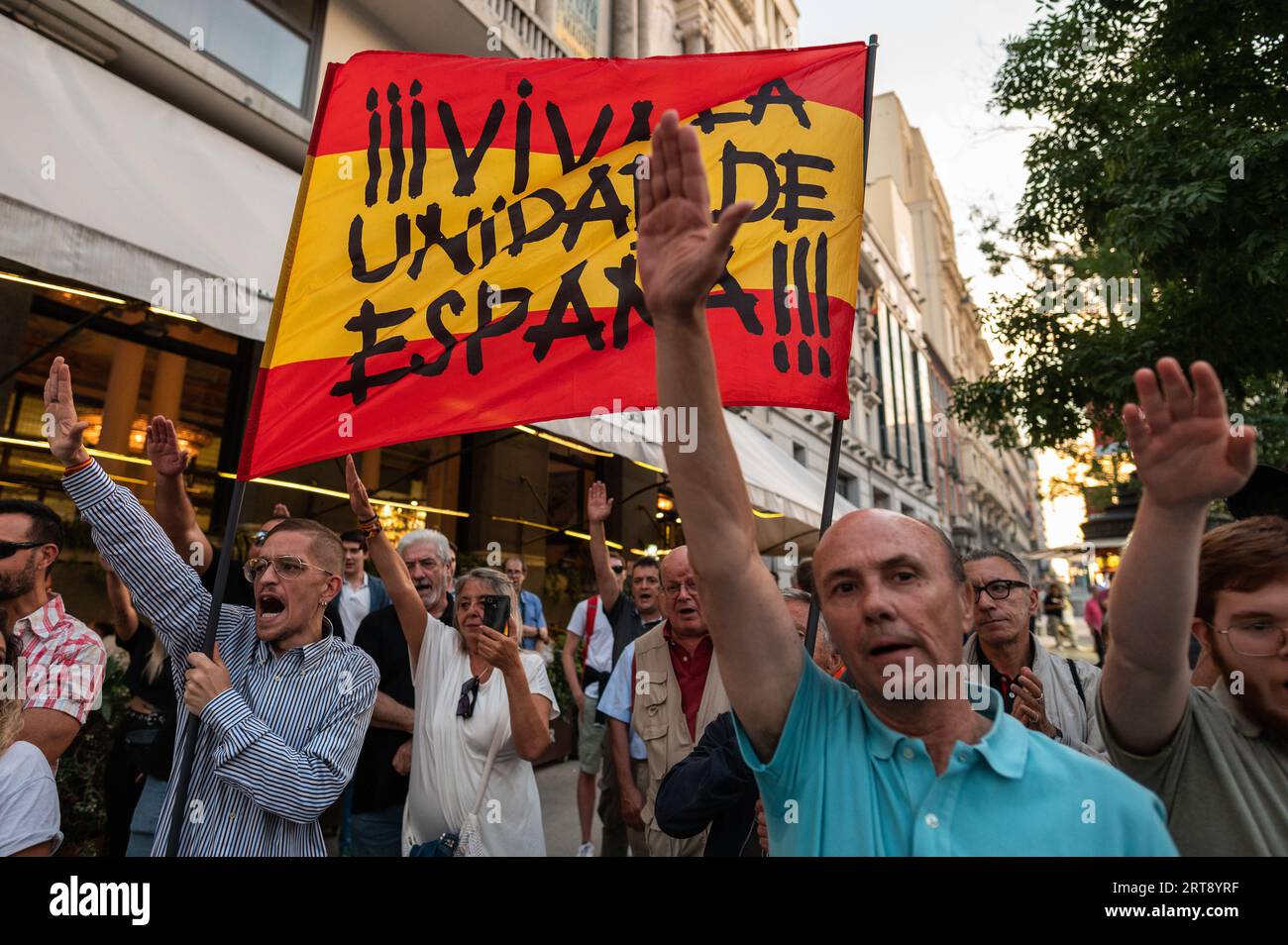 Madrid, Spagna. 11 settembre 2023. I manifestanti che alzano le mani salutano i nazisti portando con sé una bandiera spagnola con le parole "lunga vita all'unità di Spagna" si vedono durante una protesta del partito di estrema destra "Falange Española de las JONS". Il partito di estrema destra chiede il divieto dei partiti politici e delle associazioni che promuovono il separatismo, durante una protesta che coincide con la giornata nazionale catalana, nota anche come "Diada”. Crediti: Marcos del Mazo/Alamy Live News Foto Stock