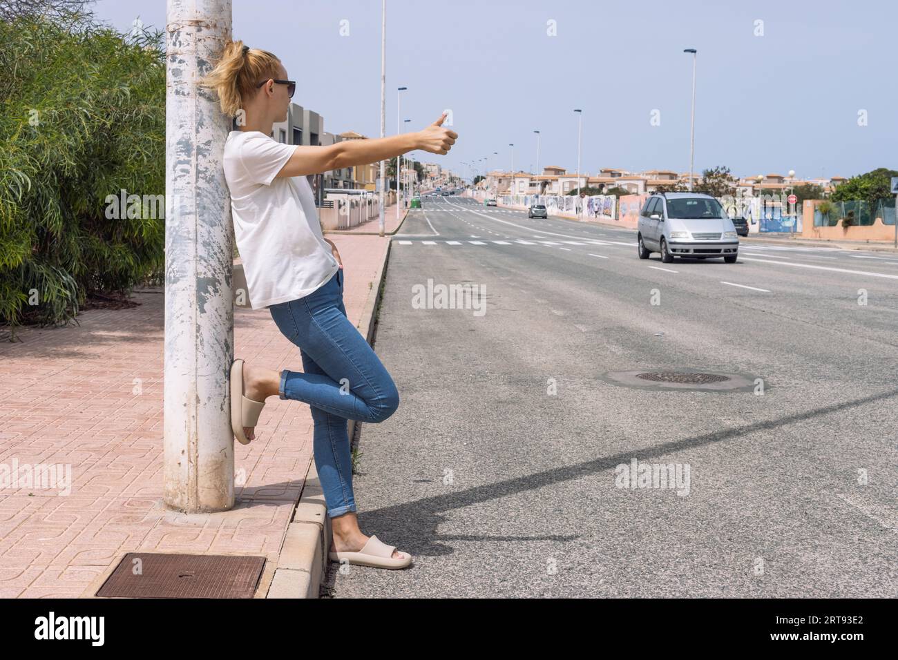 La giovane donna prende un'auto sulla strada, arresto automatico, frenata automatica, viaggio, viaggio Foto Stock