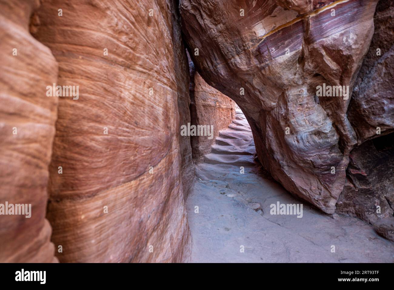 Uno stretto passaggio tra le rocce sul sentiero per il monastero (edificio ad Deir9, sito archeologico di Petra, Giordania Foto Stock