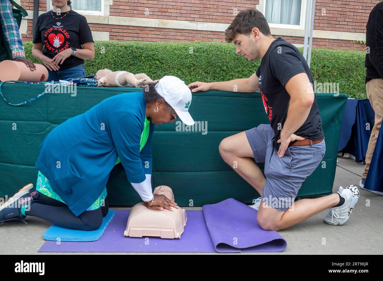 Detroit, Michigan - ad una festa sponsorizzata dal Dipartimento della salute di Detroit, una donna impara ad aiutare una vittima di arresto cardiaco improvviso usando CA Foto Stock
