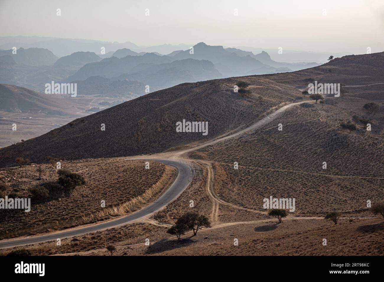 Una strada sinuosa in un paesaggio semi-arido, la Giordania Foto Stock