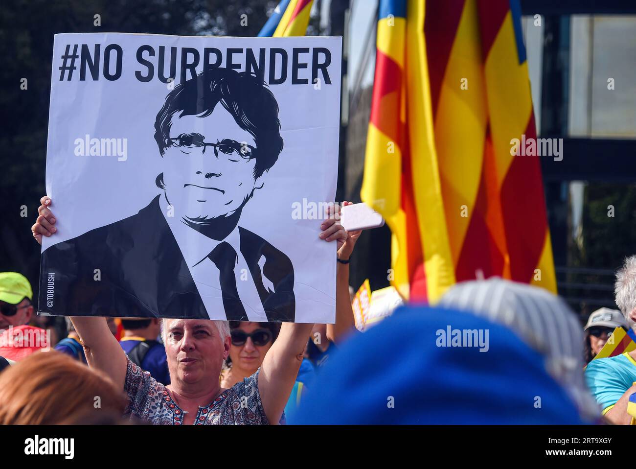 Barcellona, Spagna. 11 settembre 2023. Una donna mostra un cartello accanto a una bandiera dell'indipendenza con il volto dell'ex presidente della Catalogna Carles Puigdemont con il motto "non arrendersi" durante la manifestazione della giornata Nazionale della Catalogna. Secondo la polizia locale di Barcellona, circa 115.000 persone hanno partecipato alla manifestazione di indipendenza indetta dall'ANC (Assemblea Nazionale della Catalogna) in occasione della giornata dell'11 settembre, che è iniziata da 4 diversi punti della città. (Foto di Ramon Costa/SOPA Images/Sipa USA) credito: SIPA USA/Alamy Live News Foto Stock