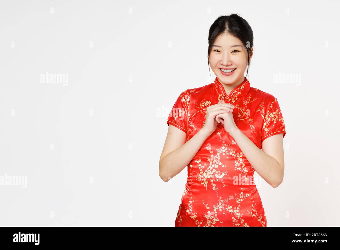 Felice anno nuovo cinese. Donna asiatica che indossa un tradizionale abito qipao cheongsam con gesto di gratitudine isolato su sfondo bianco. Foto Stock