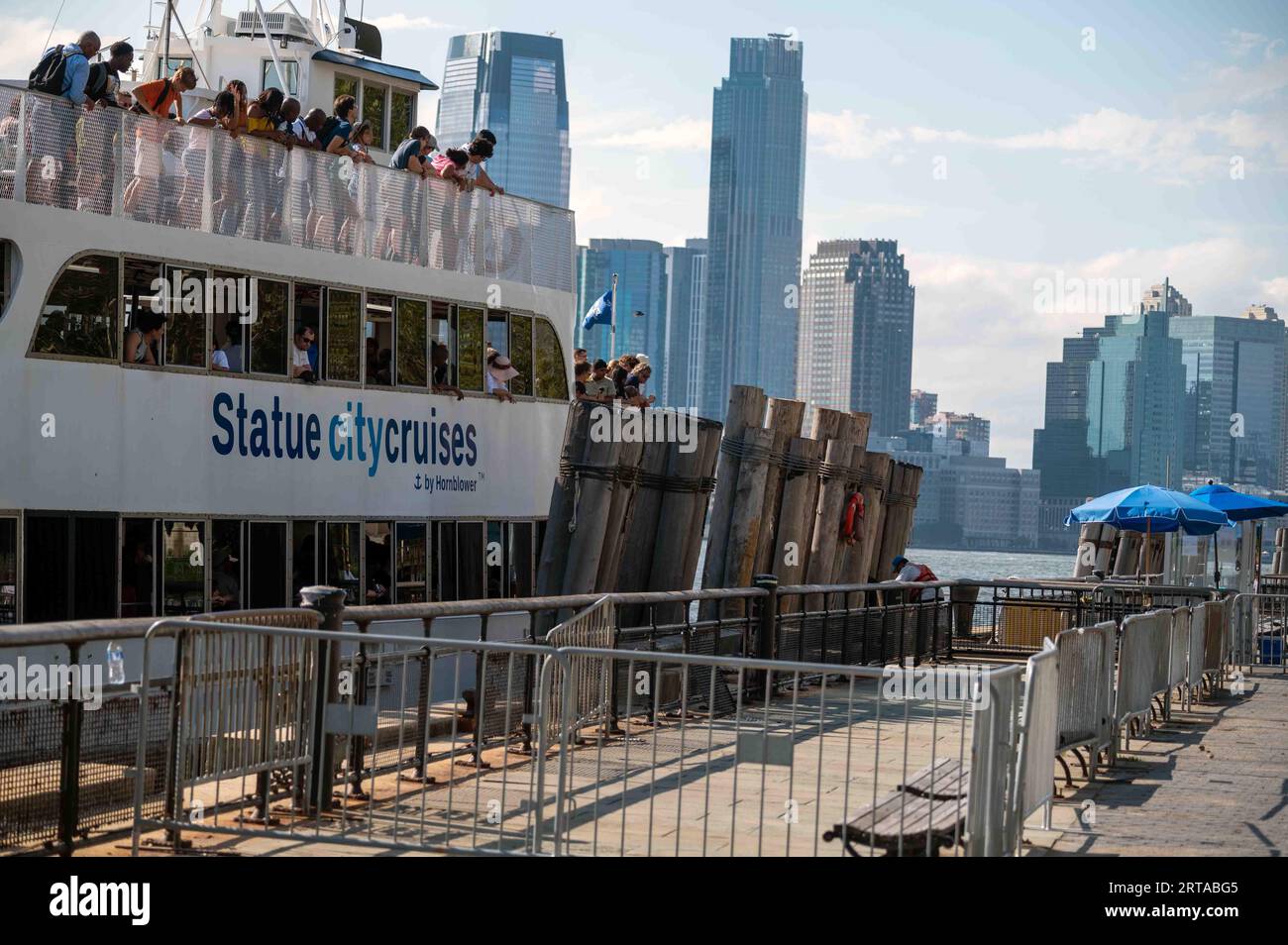 Turisti in barca per crociera Statue City sullo sfondo dello skyline di New York Foto Stock