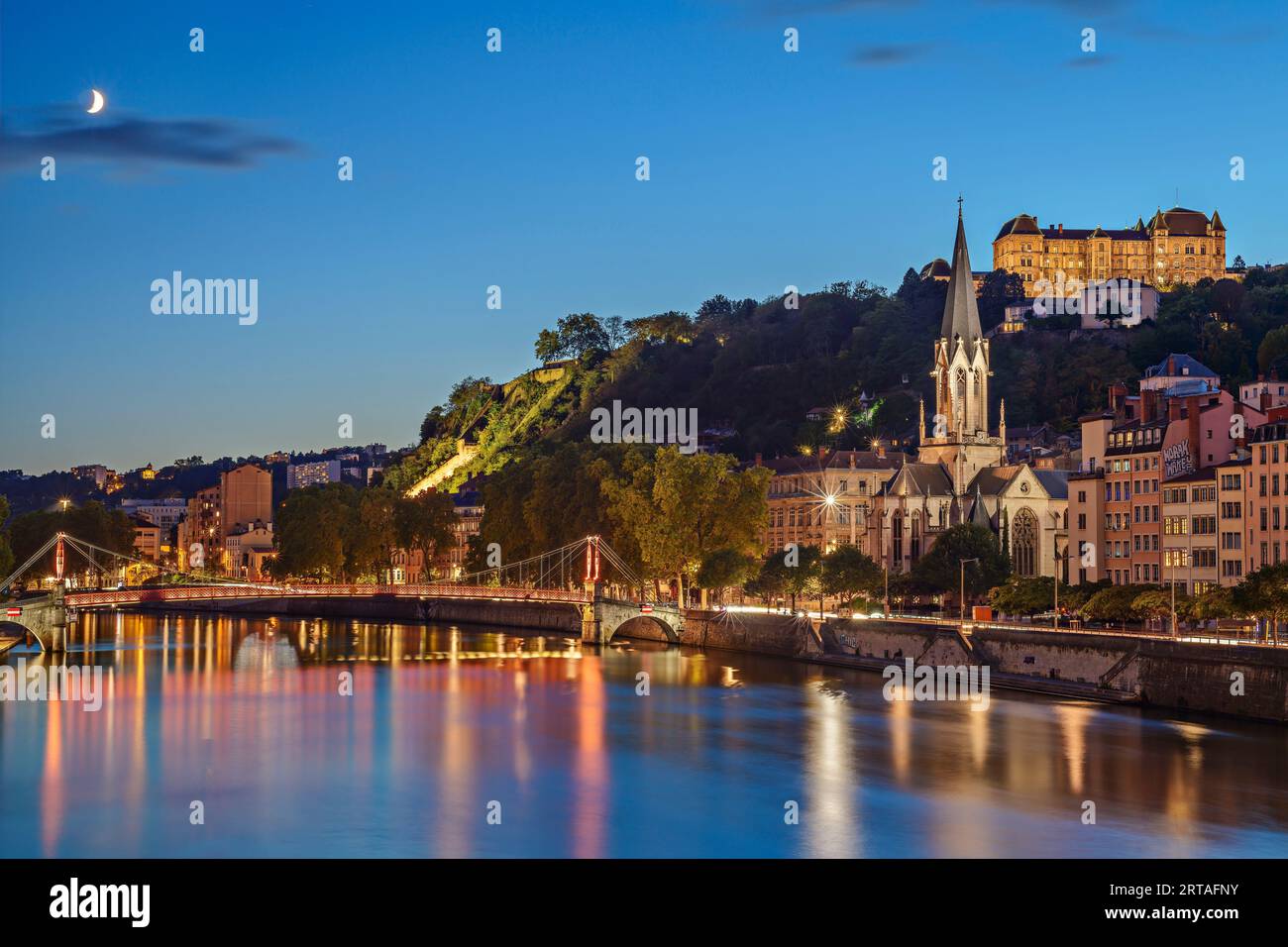 Chiesa illuminata di Église Saint-Georges con Passerelle Saint-Georges sopra il Saone e il Lycee Saint-Just, Lione, Auvergne-Rhône-Alpes, Francia Foto Stock