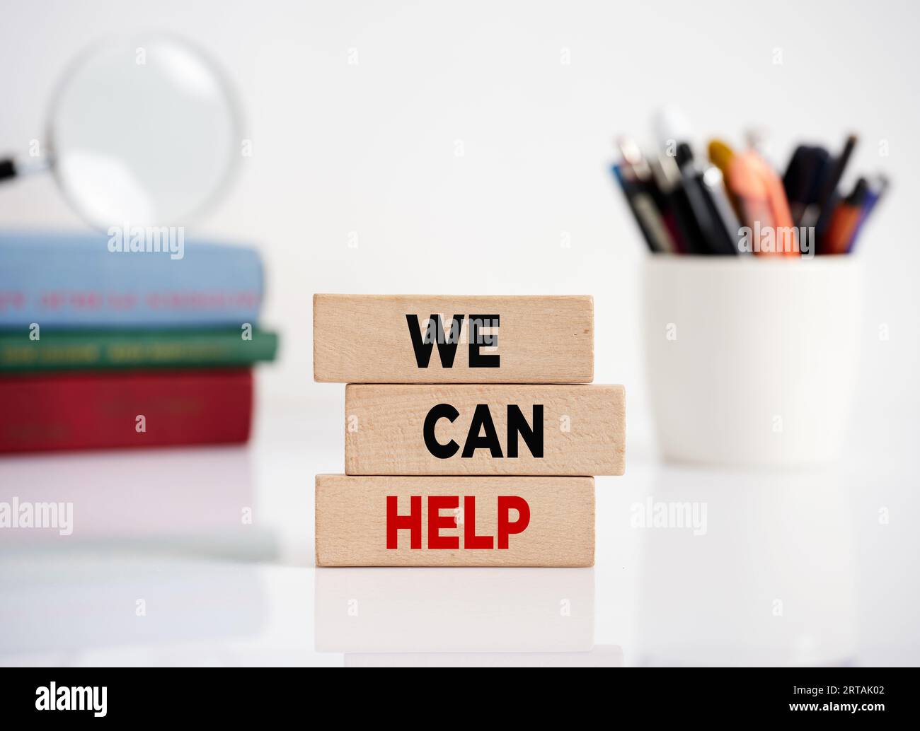 Branding o brand building nella gestione aziendale e nel marketing. Il messaggio che possiamo aiutare su blocchi di legno su una scrivania dell'ufficio. Foto Stock