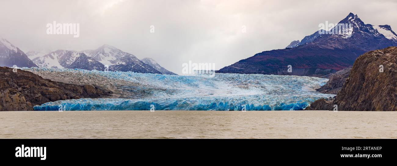 Suggestivo panorama del ghiacciaio grigio nuvoloso e turchese e delle montagne circostanti nel Parco Nazionale Torres del Paine, Cile, Patagonia, Sud Foto Stock