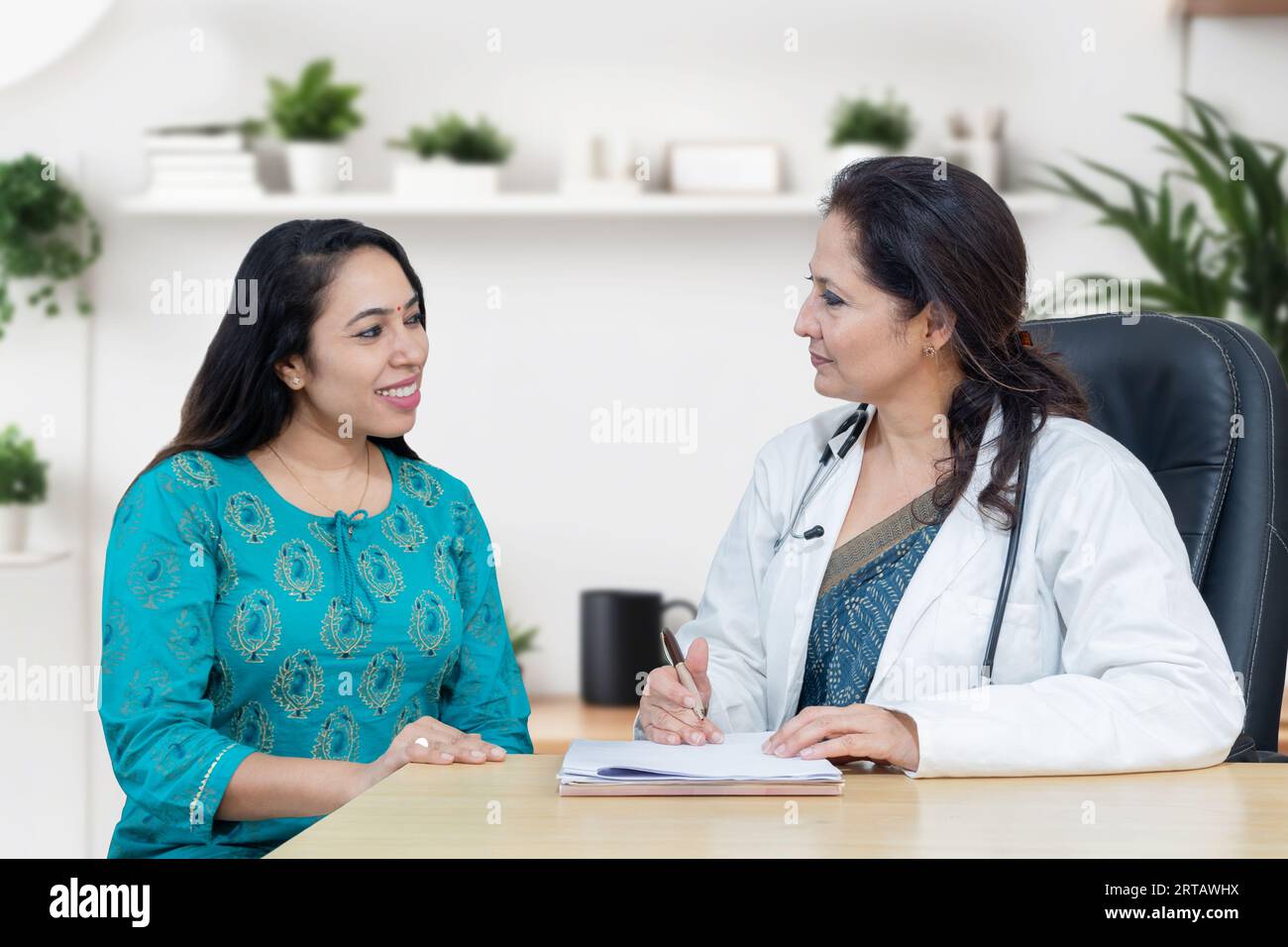 La giovane donna indiana si consulta sul suo problema con la ginecologa donna dottore in clinica moderna. Foto Stock