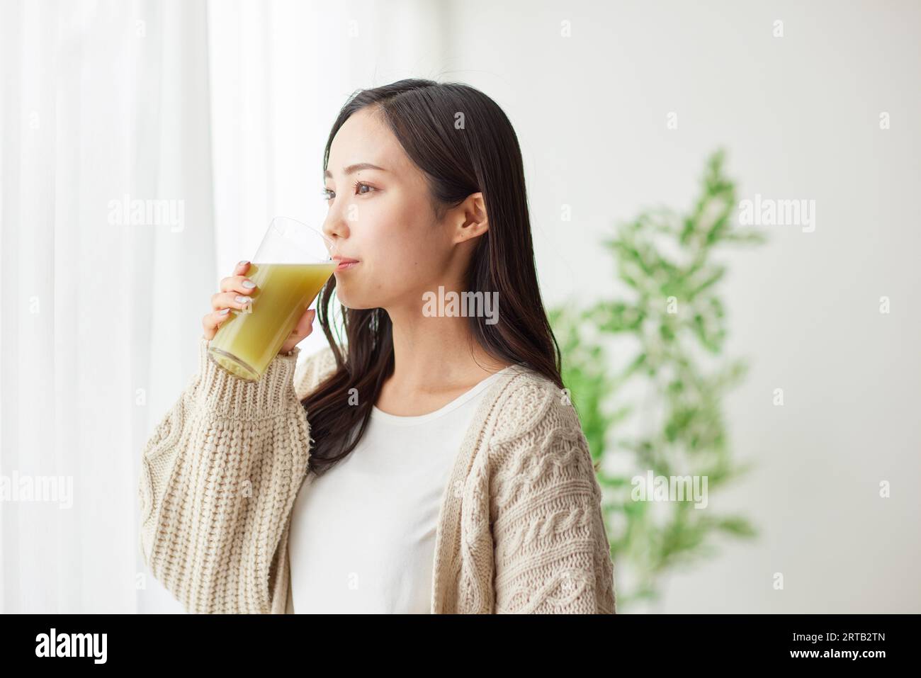 Giovane donna giapponese che beve qualcosa Foto Stock