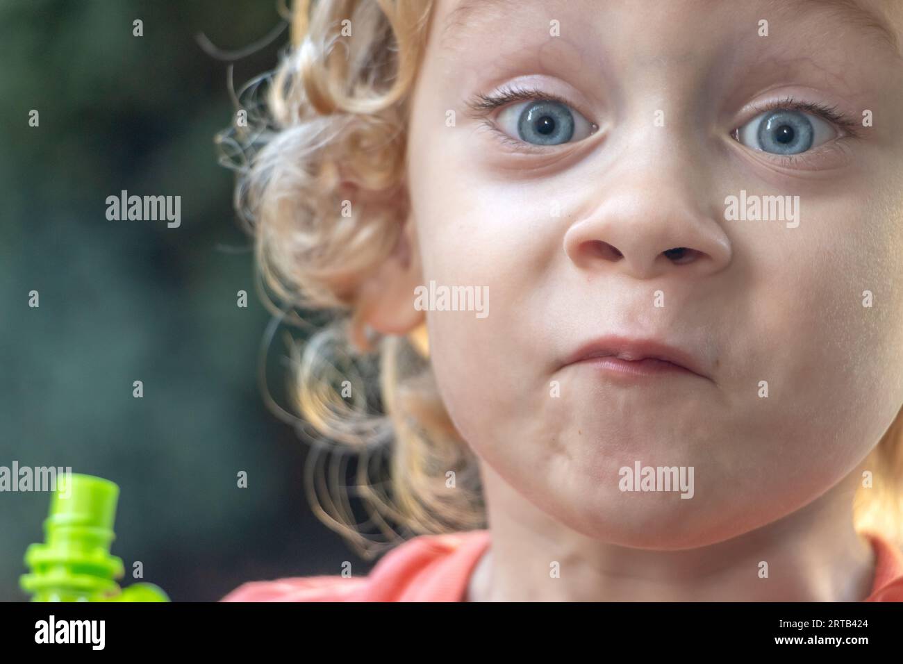 Ritratto di un ragazzo con espressioni facciali dopo aver assaggiato cibo liquido da una bustina Foto Stock
