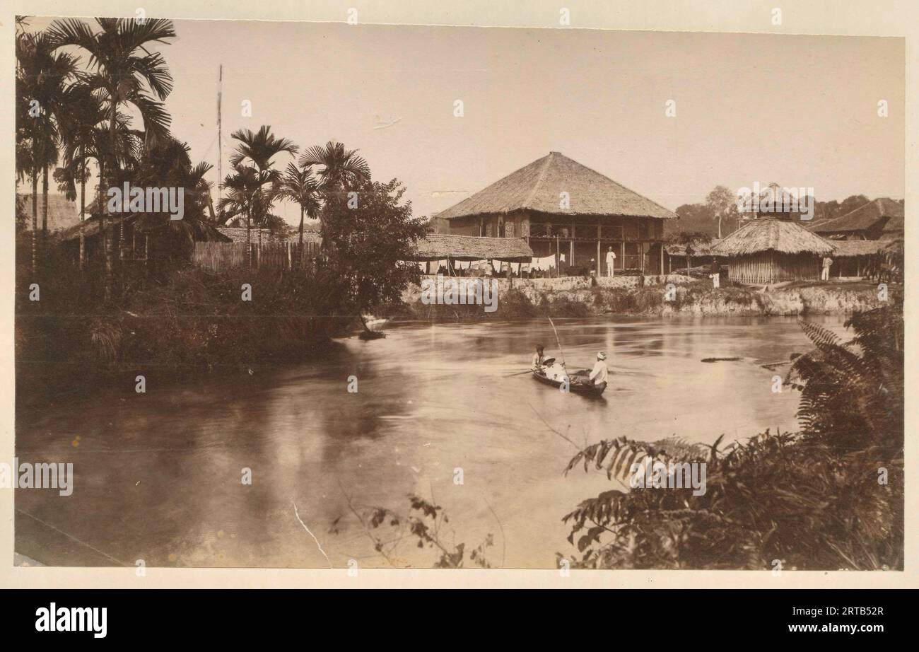 Colonialismo europeo in Indonesia, 1900, 1890, veduta delle case degli uomini europei e dei dirigenti della piantagione lungo il fiume. Probabilmente Langkat, Sumatra. Foto Stock