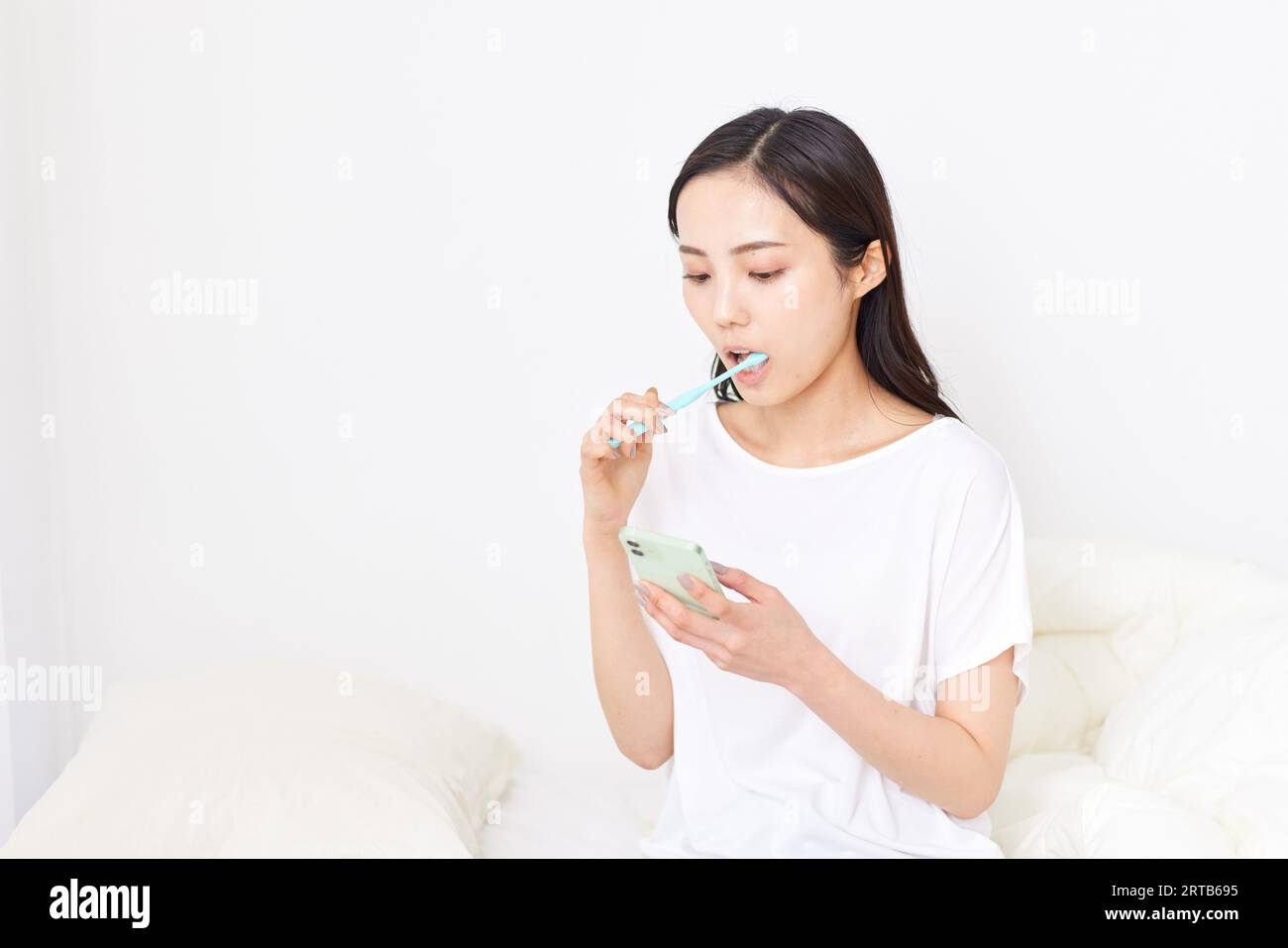 Giovane donna giapponese che pulisce i denti Foto Stock