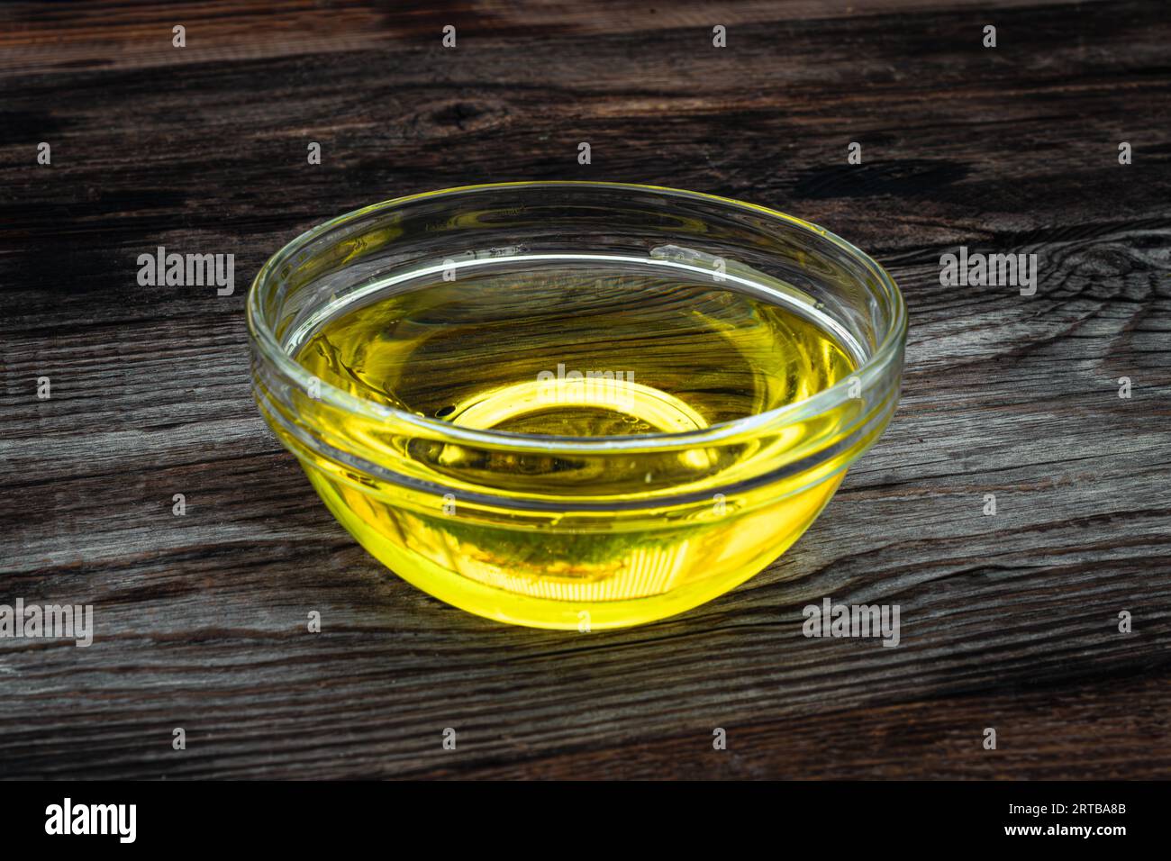 Caraffa in vetro con olio su fondo di legno scuro Foto Stock