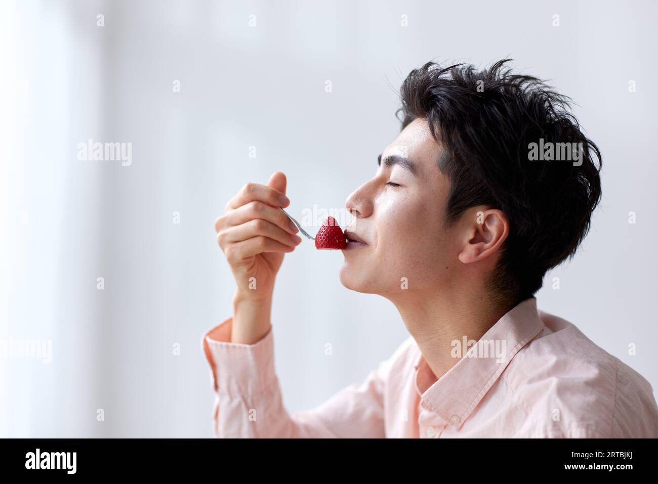 Uomo giapponese che mangia a casa Foto Stock