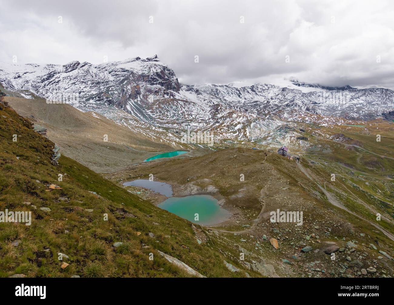 Breuil-Cervinia (Italia) - Una vista sulla città montana di Cervinia con la cima delle Alpi Cervino, i sentieri escursionistici e il lago turistico Lago Blu, Valle d'Aosta Foto Stock