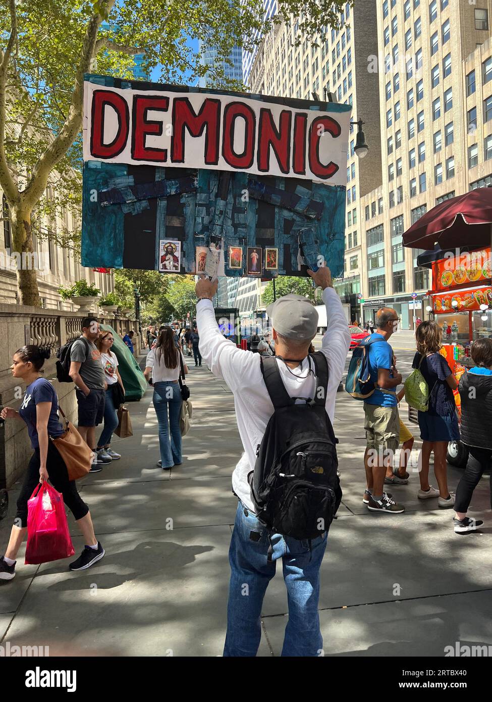 L'uomo con un grande segno all'angolo tra la 5th Avenue e la 42nd Street, parla coraggiosamente contro il cosiddetto programma del risveglio che sente spesso immorale e demoniaco come dice da un lato del suo segno. New York City. Foto Stock