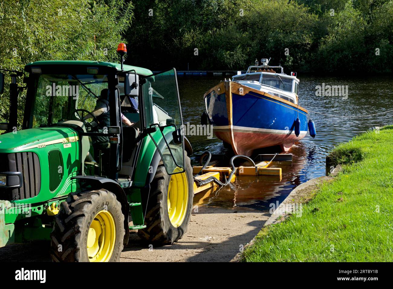 Imbarcazione in fase di lancio, con trattore, sul fiume Ouse, ad Acaster Maine, Acaster Malbis, North Yorkshire, Inghilterra, Regno Unito Foto Stock