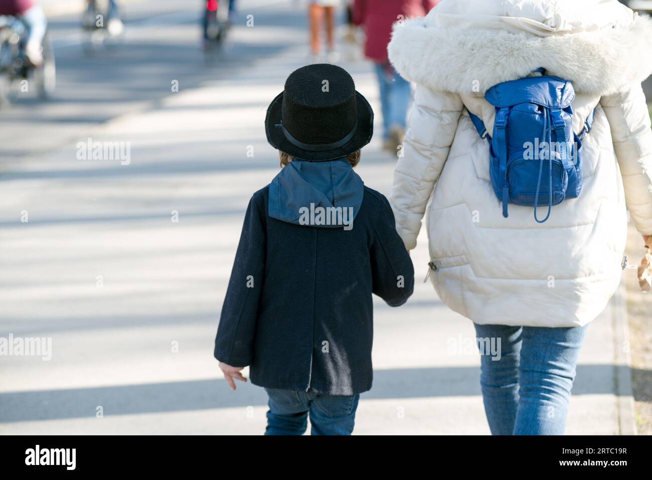Bambino in costume da favola che cammina mano nella mano con la donna Foto Stock