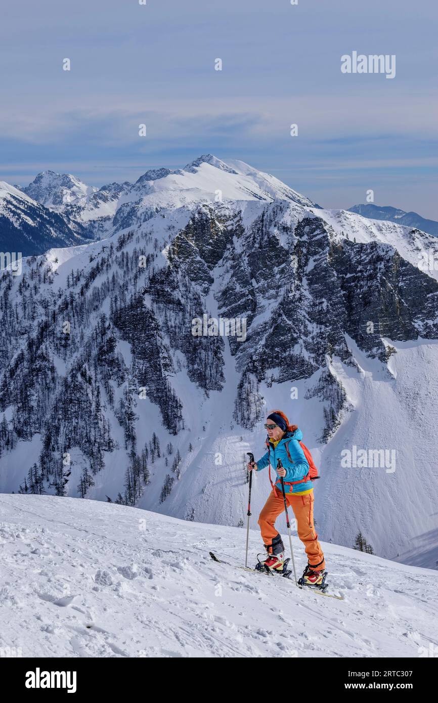 Donna in scialpinismo ascendente a Kleiner Frauenkogel, Hahnkogel e Hochstuhl in background, Kleiner Frauenkogel, Rosental, Karawanken, Carinzia, Austr Foto Stock