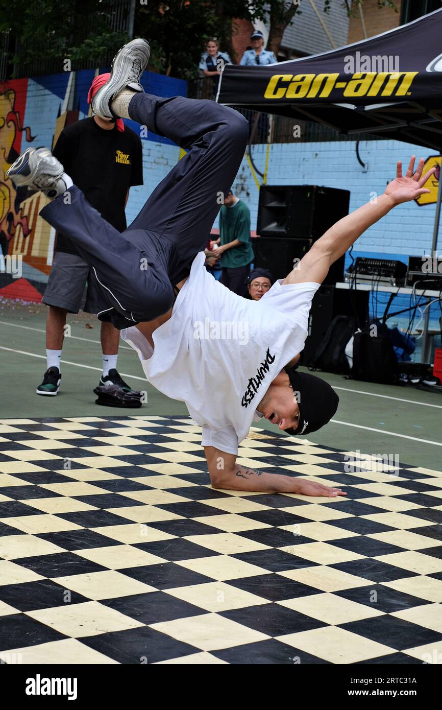 Elbow Freeze - spettacolo di breakdance, un uomo a testa in giù in una gara di danza e battaglie sui campi da basket di Woolloomooloo, Sydney Foto Stock