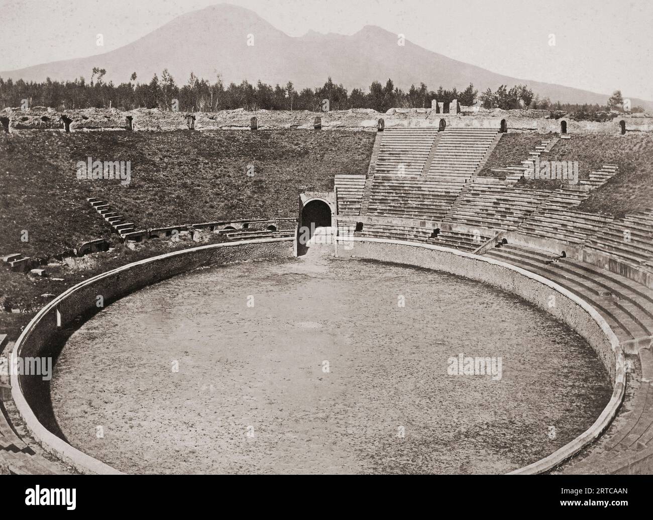 Sito archeologico di Pompei, Campania, Italia. L'anfiteatro scavato com'era alla fine del XIX secolo. MT. Il Vesuvio, il vulcano che ha distrutto la città, può essere visto sullo sfondo. Foto Stock