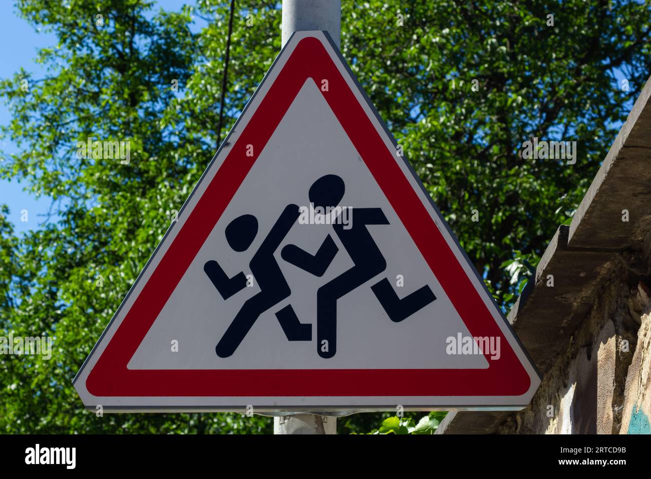 Cartello stradale Bambini, contro un albero all'ombra. Foto Stock